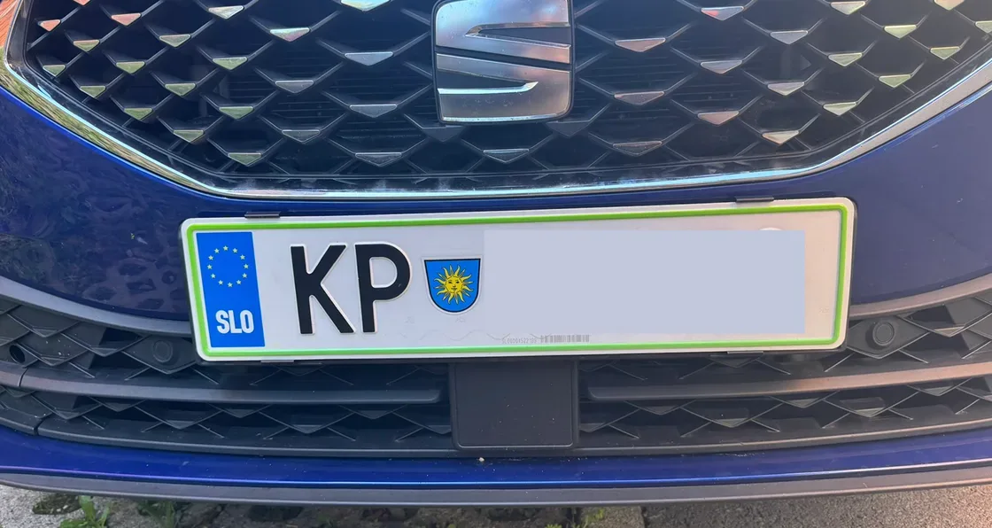 Nosilec Pritrdi.me na sprednji tablici modrega SEAT Leona